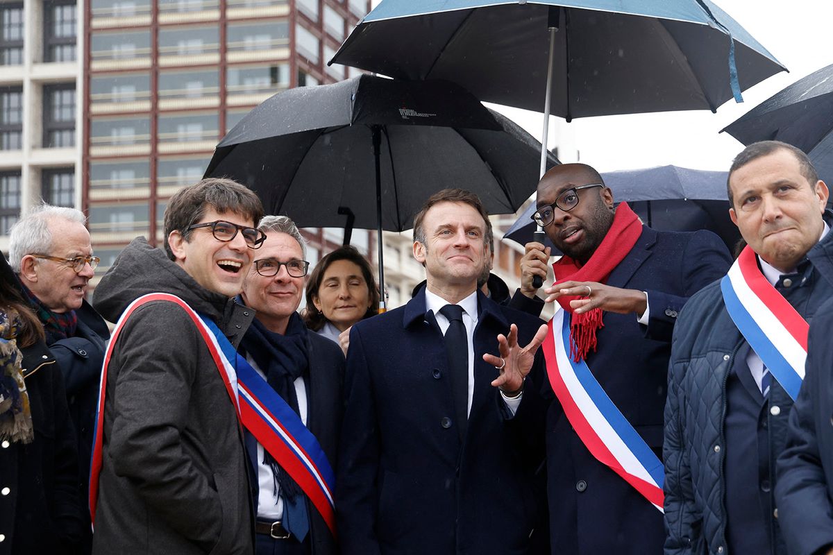 L'Ile-Saint-Denis' mayor Mohamed Gnabaly (2nd R) speaks with France's President Emmanuel Macron (C), next to Seine Saint-Denis' Council member Stephane Troussel (3rd L) and Saint-Denis' mayor Mathieu Hanotin (2nd L) during the inauguration of the Paris 2024 Olympic village in Saint-Denis, northern Paris, on February 29, 2024. The village, constructed on a 52-hectare site is located on a cluster of former industrial wastelands with the centerpiece being the Cite du Cinema. (Photo by Ludovic MARIN / POOL / AFP)