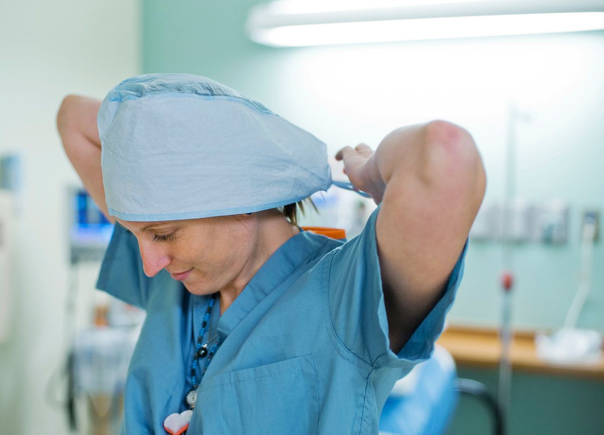 Nurse tying on surgical hat