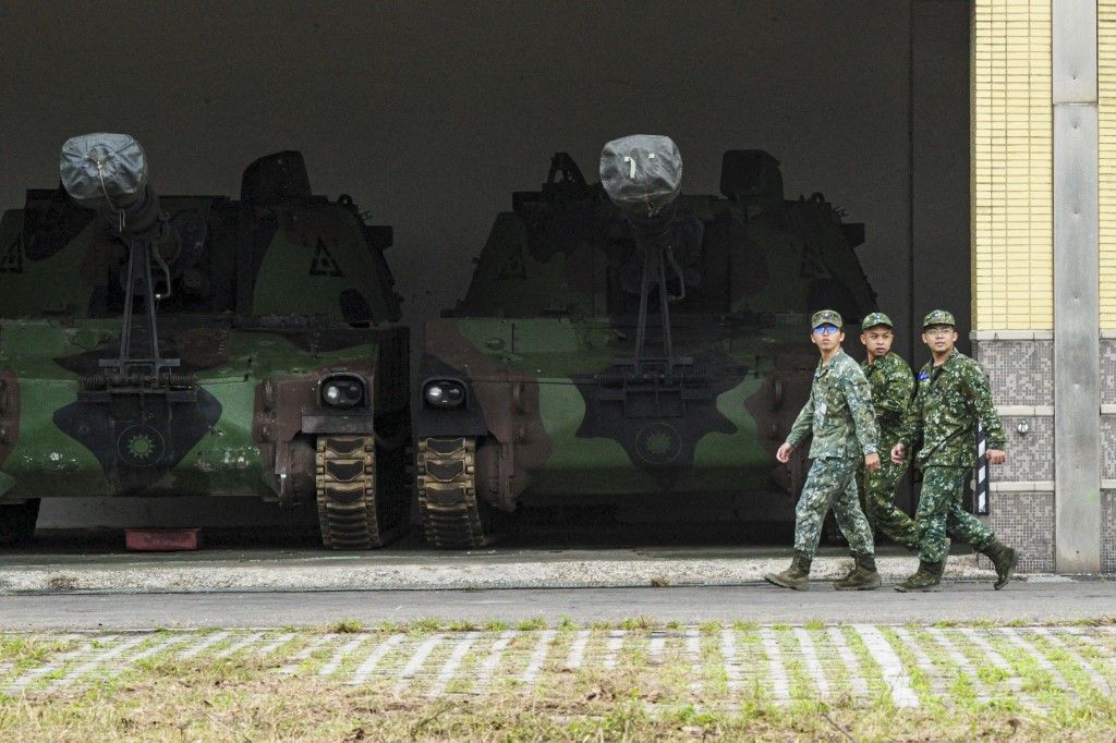 Taiwanese soldiers walk past self-propelled artillery pieces at a military base in Hsinchu on February 6, 2024. (Photo by Sam Yeh / AFP)