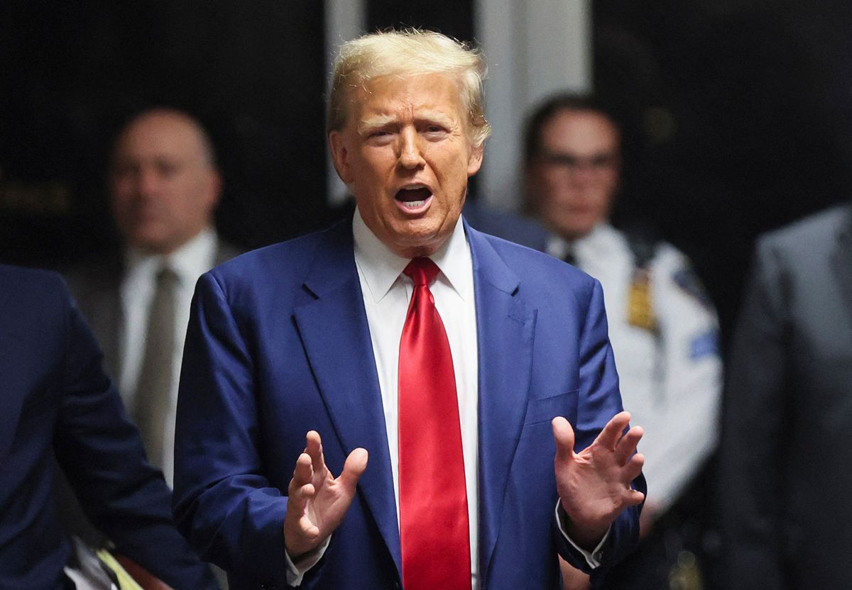 Former US President Donald Trump speaks to the press in a hallway outside the courtroom during a recess in a hearing to determine the date of his trial for allegedly covering up hush money payments linked to extramarital affairs, at Manhattan Criminal Court in New York City on March 25, 2024. Trump faces twin legal crises today in New York, where he could see the possible seizure of his storied properties over a massive fine as he separately fights to delay a criminal trial even further. (Photo by Brendan McDermid / POOL / AFP)