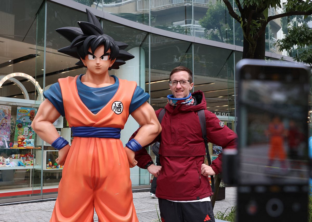 People take a photo with a statue of Son Goku, a protagonist of Dragon Ball which was created by a Japanese Manga Artist Akira Toriyama, in front of Bandai Co. in Tokyo on March 8, 2024. Toriyama, famous for manga series Dr. Slump, Dragon Ball,and others, passed away at the age of 68 on March 1st, 2024. He was also a character designer for video games such as the Dragon Quest series.( The Yomiuri Shimbun ) (Photo by Miho Takahashi / Yomiuri / The Yomiuri Shimbun via AFP)