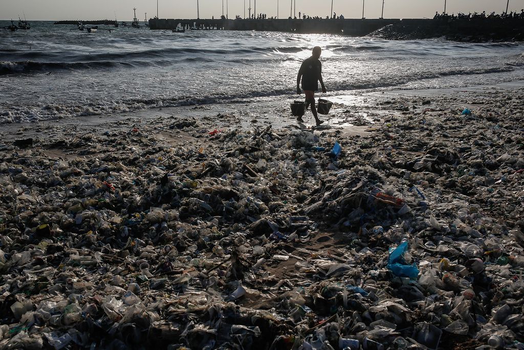 Egy férfi vödör vizet hordott műanyag hulladék között egy szennyezett parton monszun szezonban Kedonganan Beachen, Badung, Bali, Indonézia, 2024. március 19. Az esős évszakban nagy mennyiségű műanyag szemetet és törmeléket a folyókba és a part menti területeken történő illegális lerakás miatt általában a partvonalakra mosódnak, és ezzel rontják a tengerszennyezést. Indonézia a világ egyik legnagyobb tengeri műanyagszennyező országa.
Johannes Panji Christo / Anadolu (Photo by Johannes Panji Christo / ANADOLU / Anadolu via AFP)