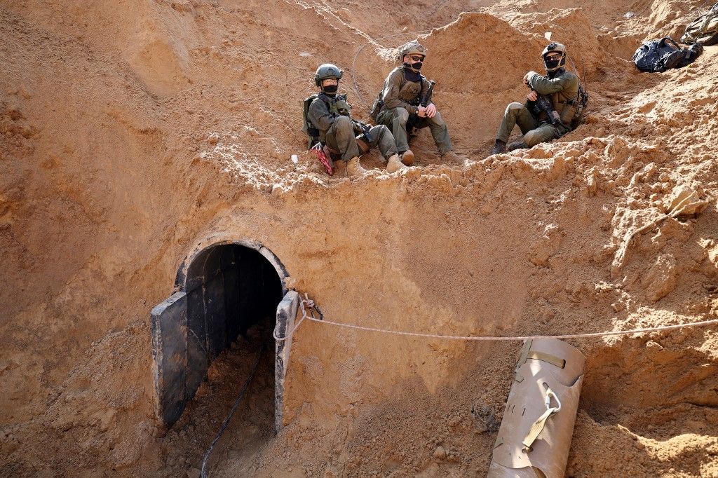--PHOTO TAKEN DURING A CONTROLLED TOUR AND SUBSEQUENTLY EDITED UNDER THE SUPERVISION OF THE ISRAELI MILITARY-- This picture taken during a media tour organised by the Israeli military on February 8, 2024, shows Israeli soldiers at the entrance of a tunnel outside the compound of the United Nations Relief and Works Agency for Palestine Refugees (UNRWA) in Gaza City, amid ongoing fighting between Israel and the Palestinian militant group Hamas. (Photo by JACK GUEZ / AFP)