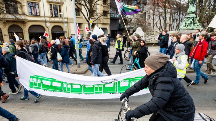 A mai napon a ver.di szakszervezet sztrájkolt, ez egy gyűjtő szakszervezet, nagyjából 1,5-2 millió taggal, és kb ezer különböző szakmát képviselnek. Ők felelnek a kollektív szerződésekért. A múlt havi mozdonyvezető sztrájk után most a közösség közlekedés/tömegközlekedési dolgozók sztrájkoltak, a jobb munkakörülményekért, meg fizetésemelésért. Tényleg brutál leterheltek, nagyon stresszes a meló, és itt is tervezett járatkimaradások vannak már (mint Budapesten), mert nincs elég buszsofőr, villamosvezető...stb.
KAV: Kommunaler Arbeitgeberverband - Kommunális Foglalkoztatók Szövetsége
Keine Ahnung (von) Verkehr : szóvicc a KAV-ból, kb Közlekedésből fogalmatlan
Verkehrswende: közlekedési reform, a Wende az a fordulat, váltás, új irány, rendszerváltás (ez a neve konkréten a 89-90es rendszerváltásnak) A közlekedés változtatása a közösségi közlekedés felé, kevesebb autó, több busz, több villamos, több bicikli...stb.
Wir fahren zusammen, wir streiken zusammen : Együtt utazunk, együtt sztrájkolunk. Kb, mint az egy csónakban evezünk.
Ob Bahn oder Bus, Sprinti ist ein Muss : Hogy vonat vagy busz, a Sprinti az kell!  (egy "muss"-muszáj)
Sprinti: gyorsbusz, iránytaxi,a külső "C" zónából a városba, vagy ott a C zónás utakra foglalható járat, kisbusz, amit appon keresztül lehet foglalni, de érvényes rá a bérlet (kb mintha über lenne BKV bérlettel)
