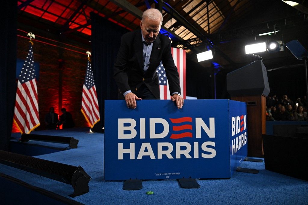US President Joe Biden looks at a pin that was thrown to him from the crowd during a campaign event in Atlanta, Georgia, on March 9, 2024. (Photo by Jim WATSON / AFP)