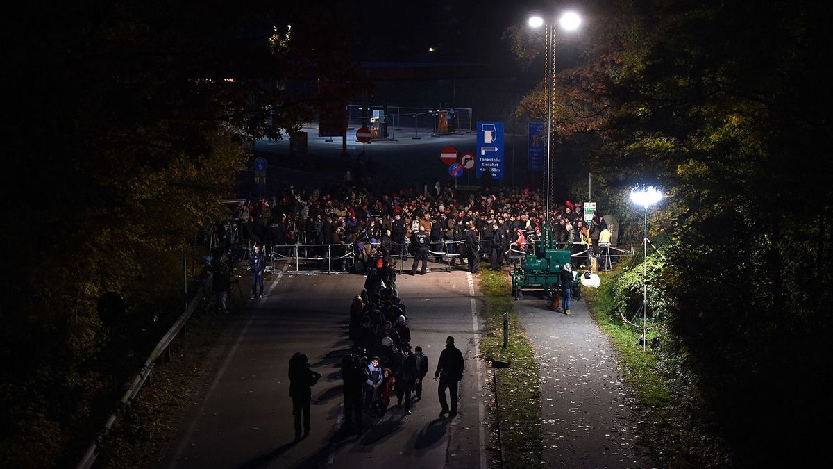 Migrants wait as night falls to cross the Austrian-German border near the Bavarian town of Passau, southern Germany, on October 28, 2015. AFP PHTO / CHRISTOF STACHE (Photo by CHRISTOF STACHE / AFP) határ