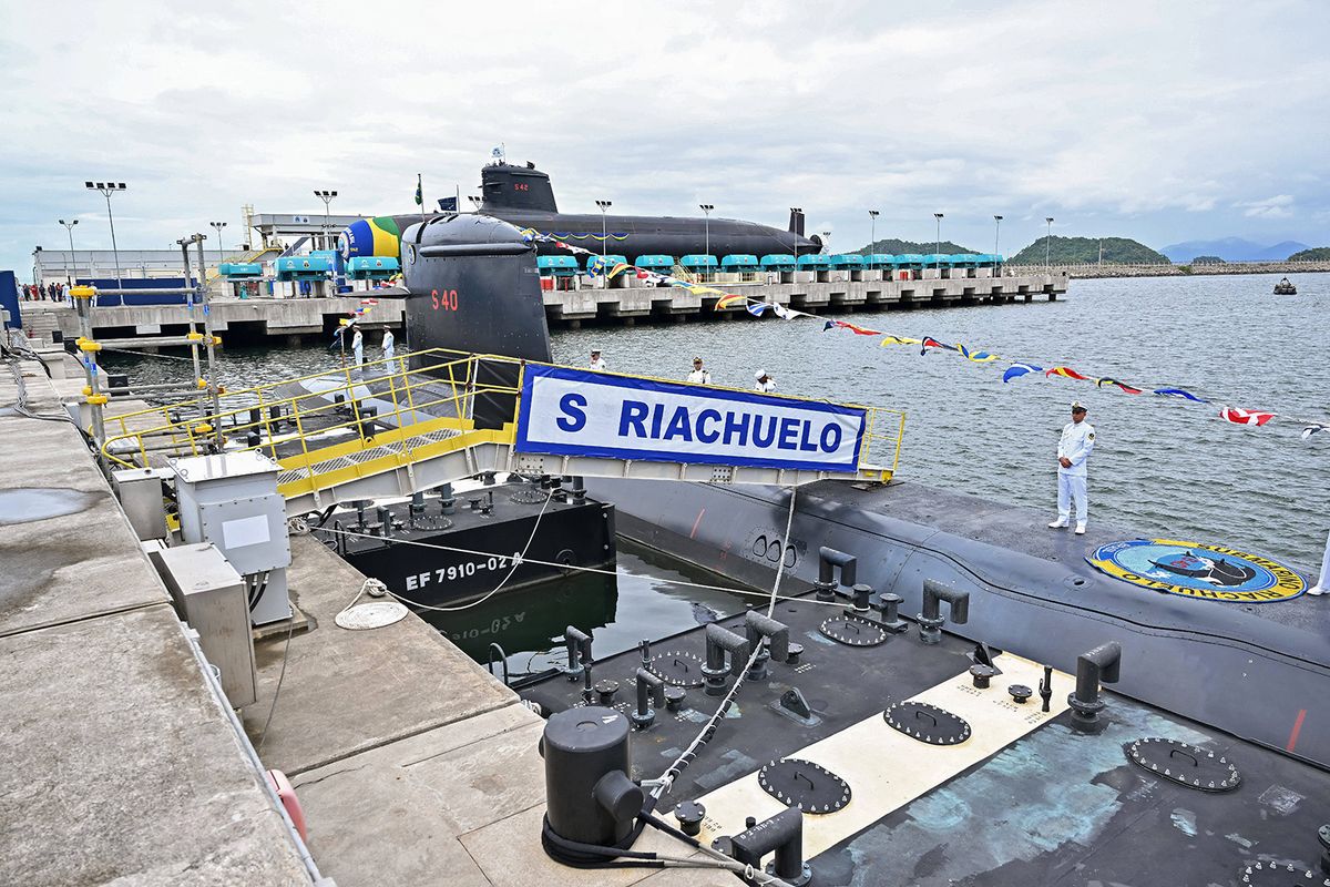 General view of the Itaguai naval base in Itaguai, Rio de Janeiro State, Brazil, taken on March 27, 2024, during the visit by Brazilian President Luiz Inacio Lula da Silva and French President Emmanuel Macron for the launching of the Tonelero submarine (background). President Emmanuel Macron told Brazil Wednesday France was "at your side" as the country seeks to develop nuclear-powered submarines, but without announcing specific collaboration on nuclear propulsion technology that Brasilia has pushed for. Macron was speaking during a ceremony to launch Brazil's third French-designed submarine, which will help secure the country's long coastline, dubbed the "Blue Amazon." (Photo by Jacques WITT / POOL / AFP)