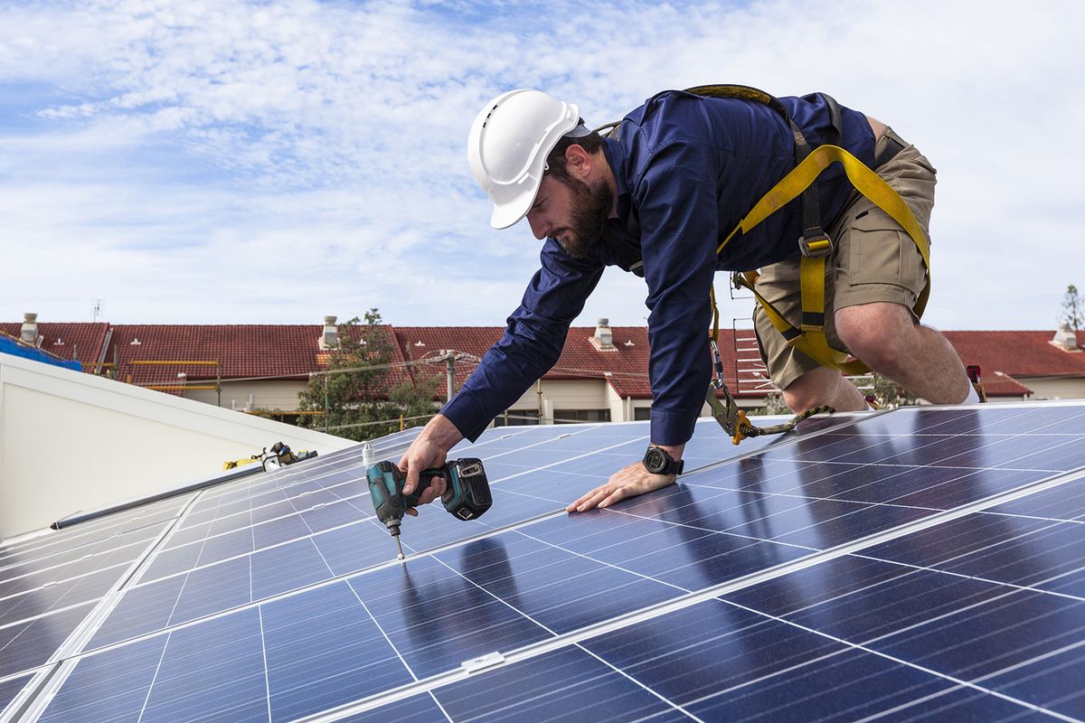 Solar,Panel,Technician,With,Drill,Installing,Solar,Panels,On,Roof