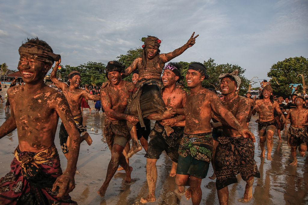 Bali férfiak az óceán felé sétálnak, miután testüket sárral fedték be az iszapfürdőzés során, vagy a Nyepi után Mebuug Buugan néven ismert Balinéz Csend napja a mangrove-területen, Kedonganan Village, Badung, Bali, Indonézia márciusban. 12, 2024. Ez a hagyomány, amelyet a faluban minden nem és korosztály gyakorol, a föld termékenységéért való hála egy formája, és úgy gondolják, hogy semlegesíti a lelki negativitást. A rituálét hatvan év kihagyás után nemrégiben újjáélesztették. 
Johannes Panji Christo / Anadolu (Photo by Johannes Panji Christo / ANADOLU / Anadolu via AFP)ty