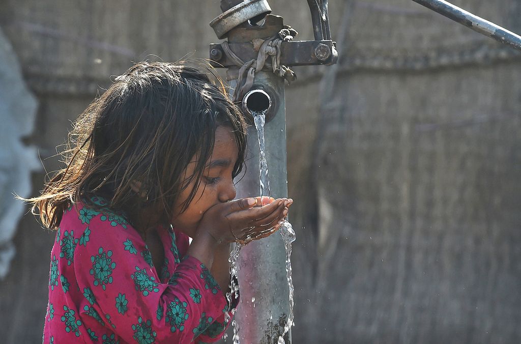 Egy pakisztáni lány vizet iszik egy kézi vízszivattyúból Lahore-ban 2019. március 22-én, a víz világnapján. UNESCO World Water Day is held annually on 22 March as a means of focusing attention on the importance of freshwater and advocating for the sustainable management of freshwater resources. (Photo by ARIF ALI / AFP)