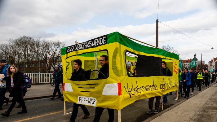 A mai napon a ver.di szakszervezet sztrájkolt, ez egy gyűjtő szakszervezet, nagyjából 1,5-2 millió taggal, és kb ezer különböző szakmát képviselnek. Ők felelnek a kollektív szerződésekért. A múlt havi mozdonyvezető sztrájk után most a közösség közlekedés/tömegközlekedési dolgozók sztrájkoltak, a jobb munkakörülményekért, meg fizetésemelésért. Tényleg brutál leterheltek, nagyon stresszes a meló, és itt is tervezett járatkimaradások vannak már (mint Budapesten), mert nincs elég buszsofőr, villamosvezető...stb.
KAV: Kommunaler Arbeitgeberverband - Kommunális Foglalkoztatók Szövetsége
Keine Ahnung (von) Verkehr : szóvicc a KAV-ból, kb Közlekedésből fogalmatlan
Verkehrswende: közlekedési reform, a Wende az a fordulat, váltás, új irány, rendszerváltás (ez a neve konkréten a 89-90es rendszerváltásnak) A közlekedés változtatása a közösségi közlekedés felé, kevesebb autó, több busz, több villamos, több bicikli...stb.
Wir fahren zusammen, wir streiken zusammen : Együtt utazunk, együtt sztrájkolunk. Kb, mint az egy csónakban evezünk.
Ob Bahn oder Bus, Sprinti ist ein Muss : Hogy vonat vagy busz, a Sprinti az kell!  (egy "muss"-muszáj)
Sprinti: gyorsbusz, iránytaxi,a külső "C" zónából a városba, vagy ott a C zónás utakra foglalható járat, kisbusz, amit appon keresztül lehet foglalni, de érvényes rá a bérlet (kb mintha über lenne BKV bérlettel)