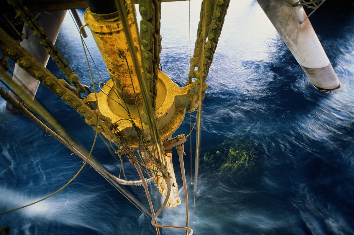 Oil rig drilling pipe at surface of water
