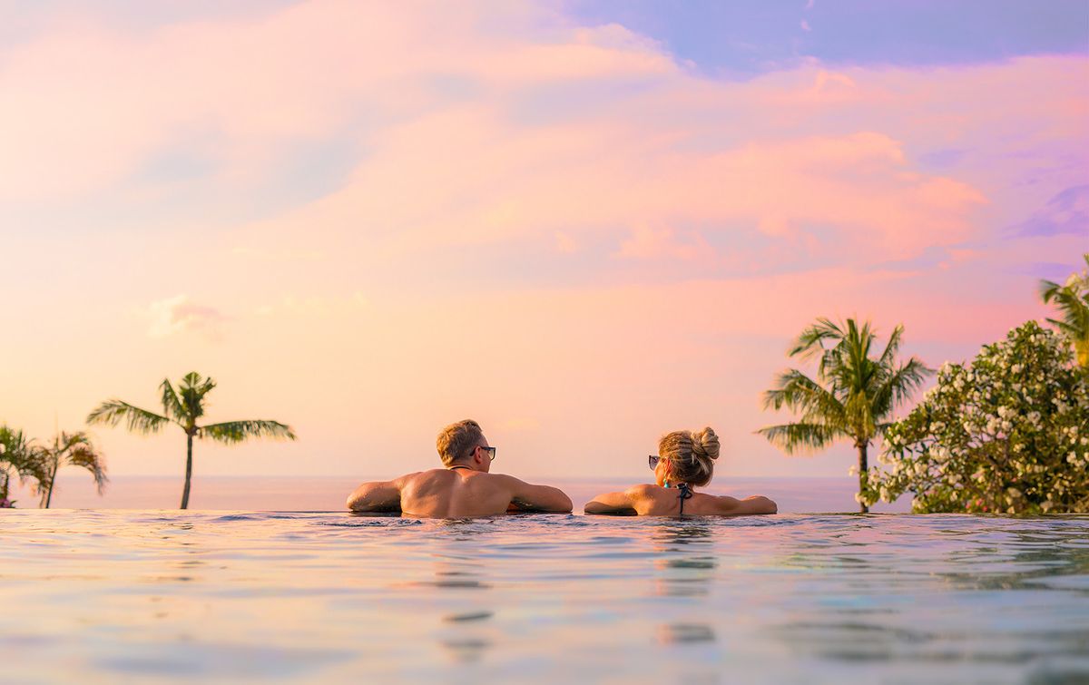 Romantic,Couple,Looking,At,Beautiful,Sunset,In,Luxury,Infinity,Pool