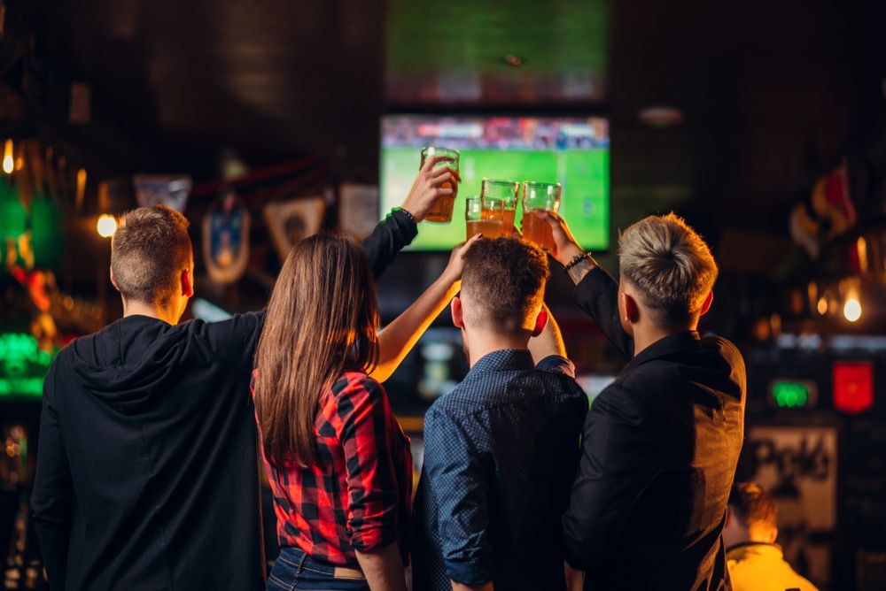 Friends,Watches,Football,On,Tv,In,A,Sport,Bar