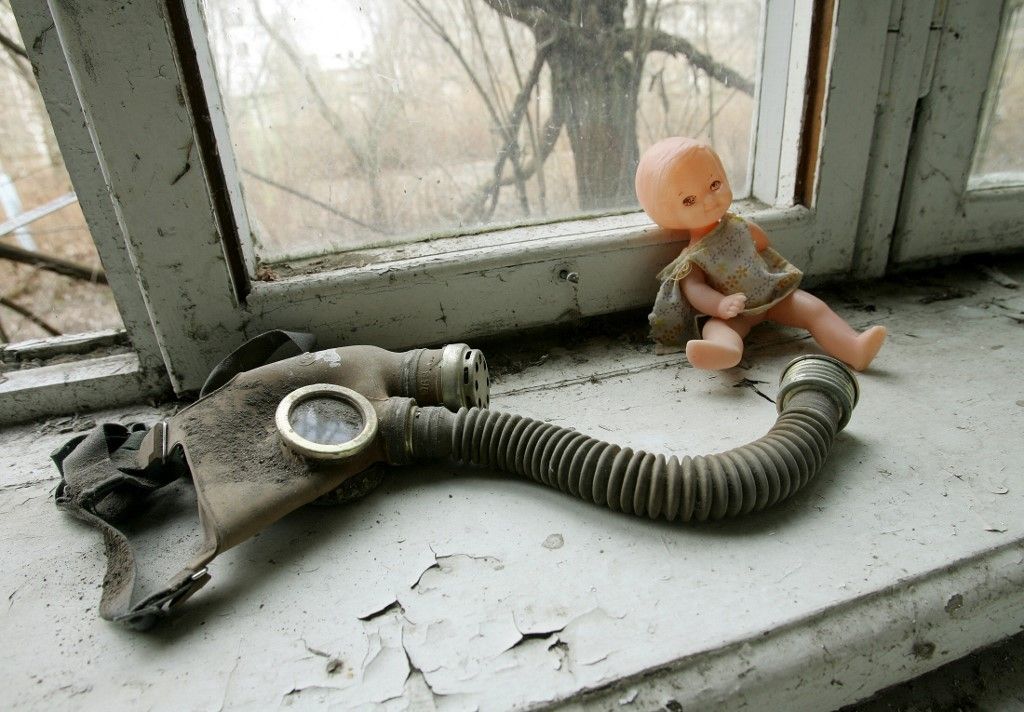 A picture taken 20 April 2006 shows a gas mask near a doll at one of the kindergartens of ghost city of Pripyat, near Chernobyl's nuclear power plant.  On April 26, Ukraine marks the 20th anniversary of an accident at the Chernobyl nuclear power plant, which affected millions of people, gobbled up astronomic amount of international funds and remains a grim symbol of hazzards of atomic energy.  AFP PHOTO/  Sergei SUPINSKY (Photo by Sergei SUPINSKY / AFP)