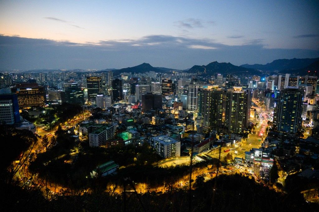 This photo taken on November 19, 2022, shows a general view of buildings amid city lights in Seoul. (Photo by ANTHONY WALLACE / AFP)