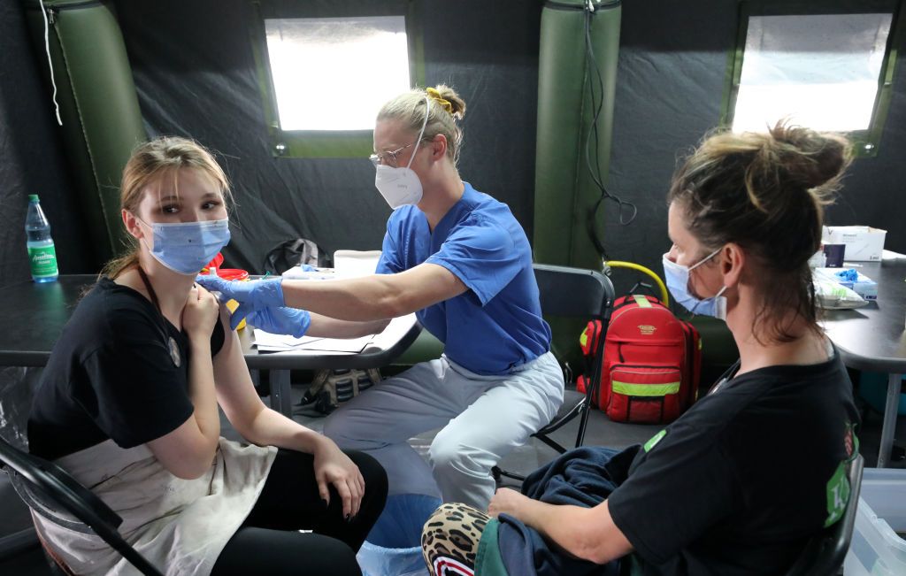 Open vaccination day at Karls20 July 2021, Mecklenburg-Western Pomerania, Rövershagen: At the second Open Vaccination Day in Karls Erlebnis-Dorf, two women will be vaccinated in a Bundeswehr tent in the parking lot. Together with the Rostock district and the German Armed Forces, Karls invites you to another vaccination day on 20-21.07.2021, where everyone from the age of 16 can participate without registration, 250 doses of Biontech/Pfizer are available on each day. The first Open Vaccination Day took place on 08.07.2021. Photo: Bernd Wüstneck/dpa-Zentralbild/dpa (Photo by Bernd Wüstneck/picture alliance via Getty Images)