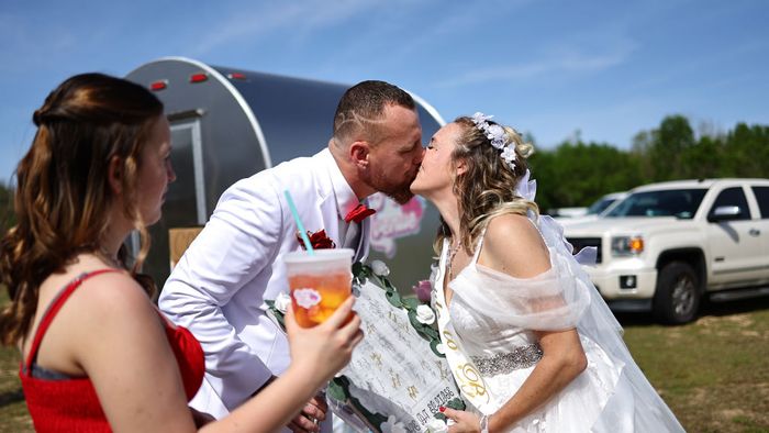 Randy és Michelle Weller menyasszony és vőlegény csókolóznak egy több mint 200 páros tömeges esküvő előtt a Total Eclipse of the Heart fesztiválon 