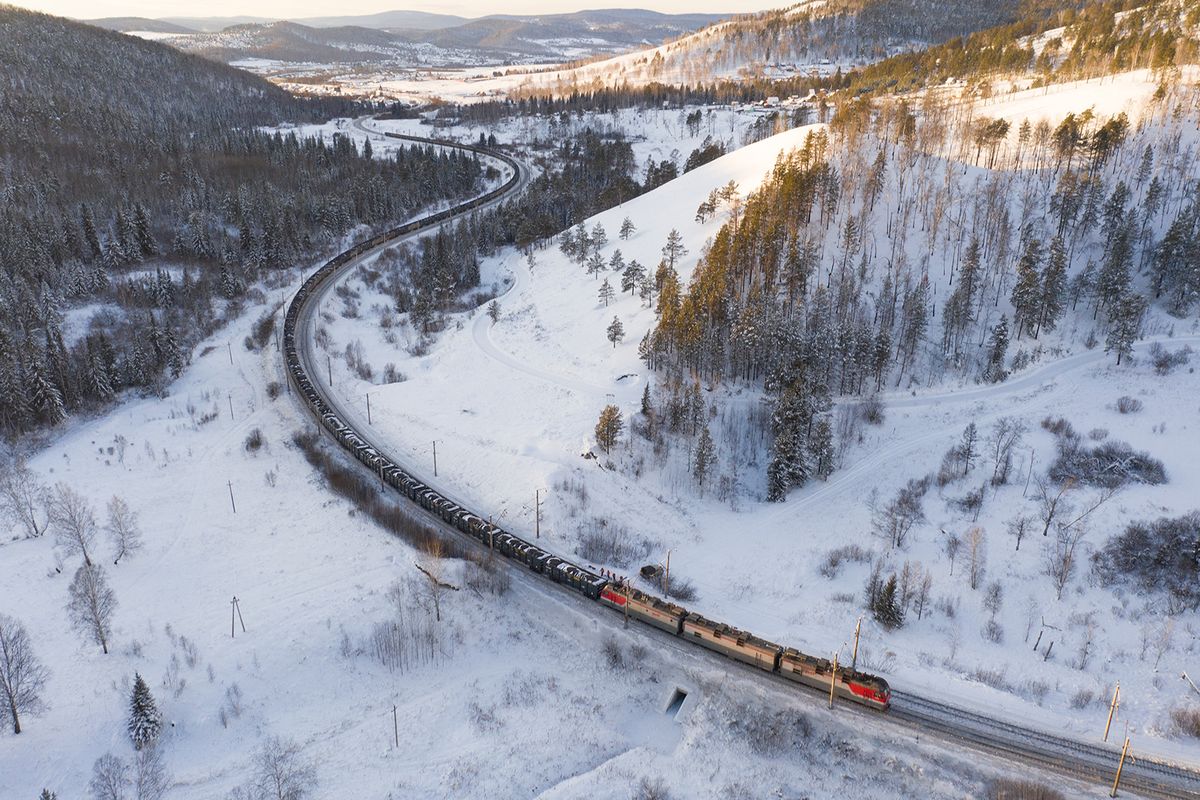 KRASNOYARSK, RUSSIA - DECEMBER 21: An aerial view of the Trans-Siberian Railway (Transsib), the main transport artery of Russia as connecting the European part of country with the largest East Siberian and Far Eastern industrial cities, in Krasnoyarsk, Russia on December 21, 2023. Since the railway has the length of 8.3 thousand km, it is considered as longest railway in Russia and the world. The section of the Trans-Siberian Railway in Krasnoyarsk has many elevation changes, as well as serpentines, as a result of which freight trains are equipped with powerful additional locomotives. In addition, the area around the railway is popular with local residents; there are many suburban areas here, and it is also popular among tourists because the hills offer picturesque views. Alexander Manzyuk / Anadolu (Photo by Alexander Manzyuk / ANADOLU / Anadolu via AFP)