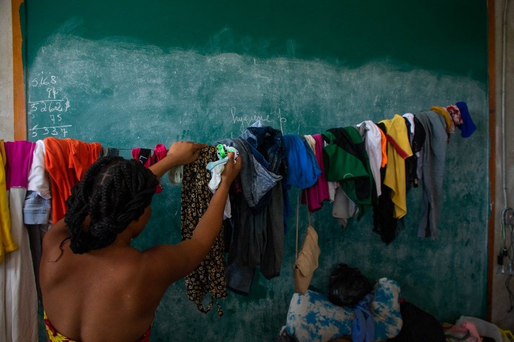 A woman hangs laundry in a school that has become a shelter for displaced people amid the gang-related violence that has wracked the country, in Port-au-Prince on 22 April 2024 (Photo by Clarens SIFFROY / AFP), Haiti