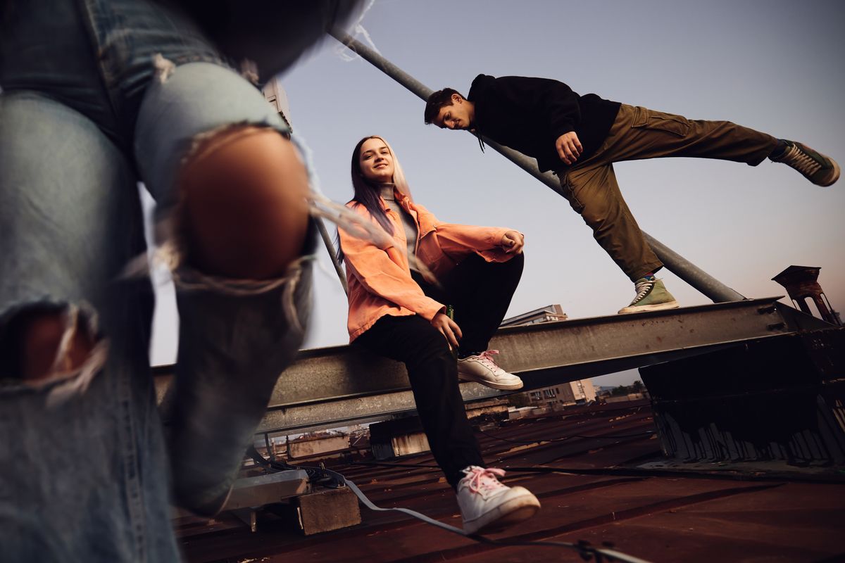 A teenagers hanging on rooftop and drinking beer.