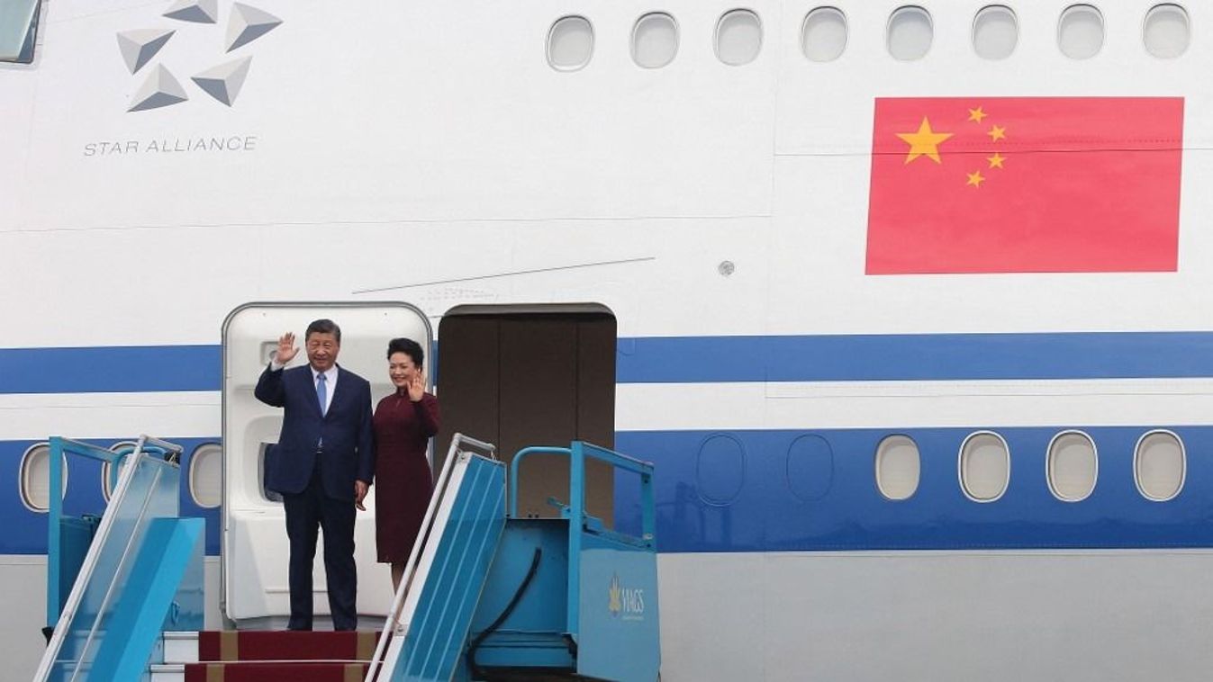 China's President Xi Jinping (L) and his wife Peng Liyuan wave as they arrive at Noi Bai International airport in Hanoi on December 12, 2023. China's President Xi Jinping arrived in Vietnam on December 12 for his first visit in six years, as he seeks to counter the United States' growing influence with the communist nation. (Photo by LUONG THAI LINH / POOL / AFP)