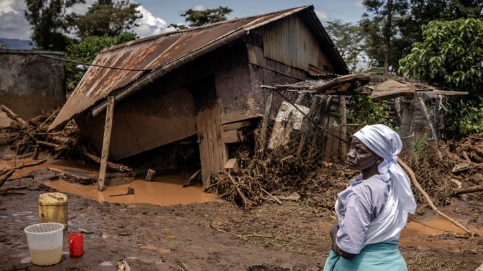 Egy nő felméri a károkat lerombolt háza előtt