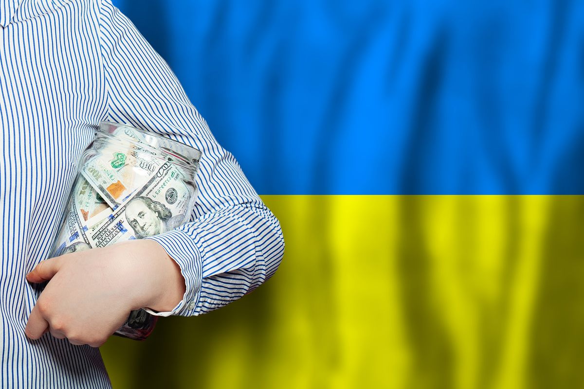 American,Dollars,Cash,Money,In,Hand,On,Flag,Of,Ukraine