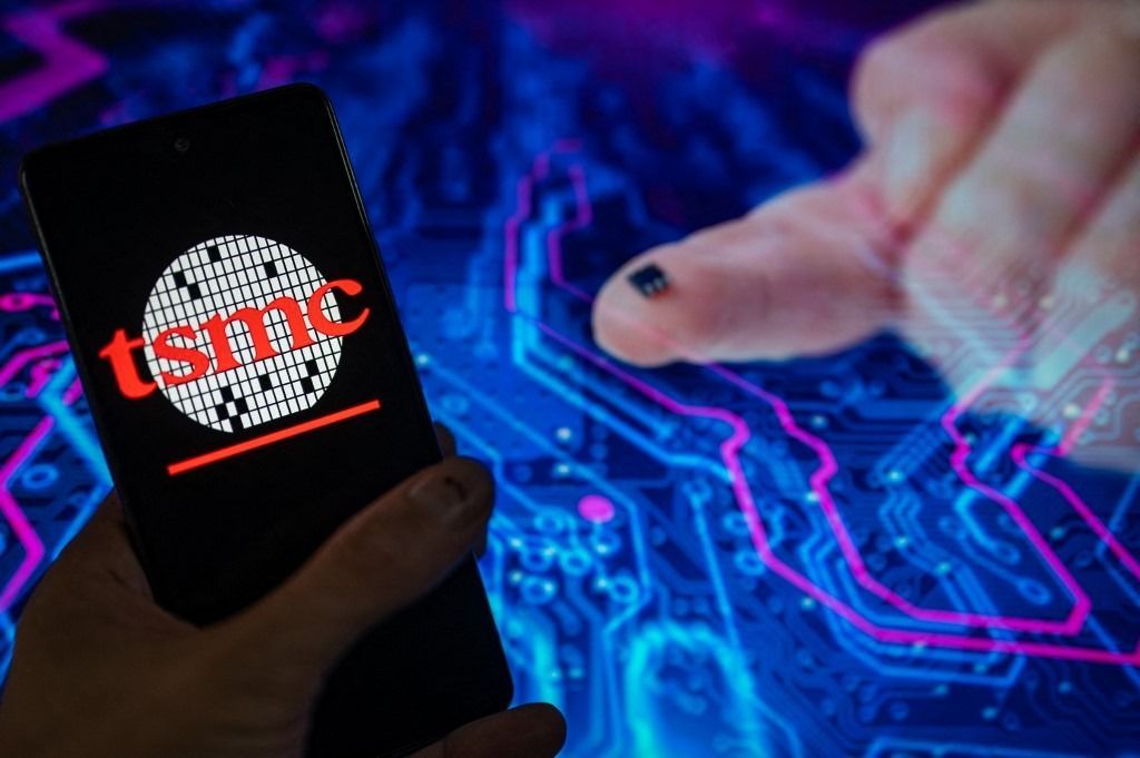 TSMC Microchip IllustrationTSMC (Semiconductor Manufacturing Company) logo displayed on a smartphone with microchip seen in the background. On 10 August 2023, in Brussels, Belgium. (Photo illustration by Jonathan Raa/NurPhoto) (Photo by Jonathan Raa / NurPhoto / NurPhoto via AFP)