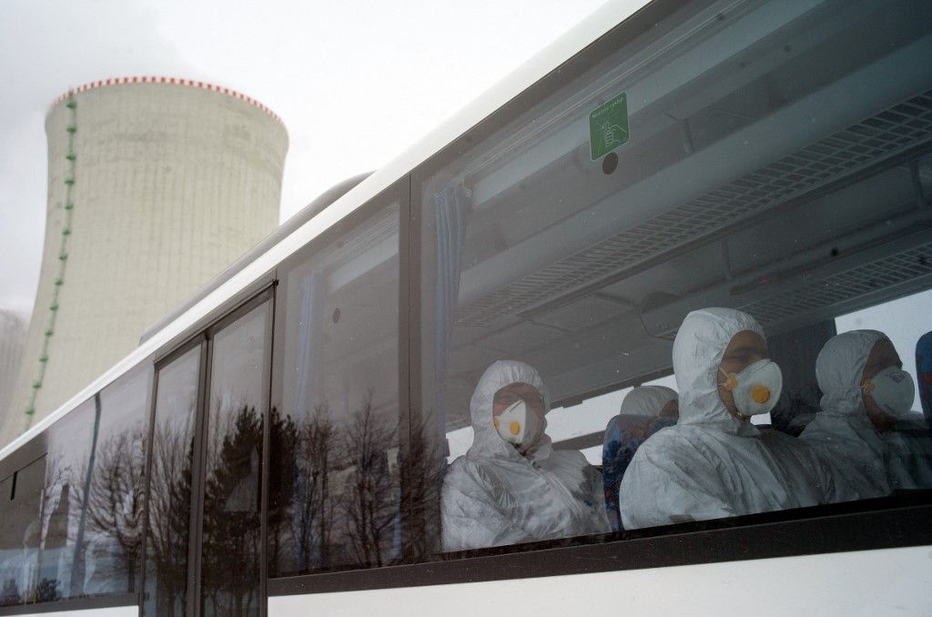 Workers of Dukovany nuclear power plant dressed in radiation protection suits sit in the bus during a nuclear accident exercise on March 26, 2013 in Dukovany nuclear power plant, 50km from the city of Brno. AFP PHOTO/MICHAL CIZEK (Photo by MICHAL CIZEK / AFP)