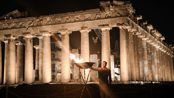 A görög 400 méteres bajnok Periklis Iakovakis meggyújt egy üstöt olimpiai lánggal a Parthenon ősi temploma előtt, az Akropolisz domb tetején.