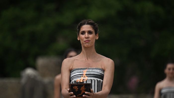 Egy színésznő tartja kezében az olimpiai lángot