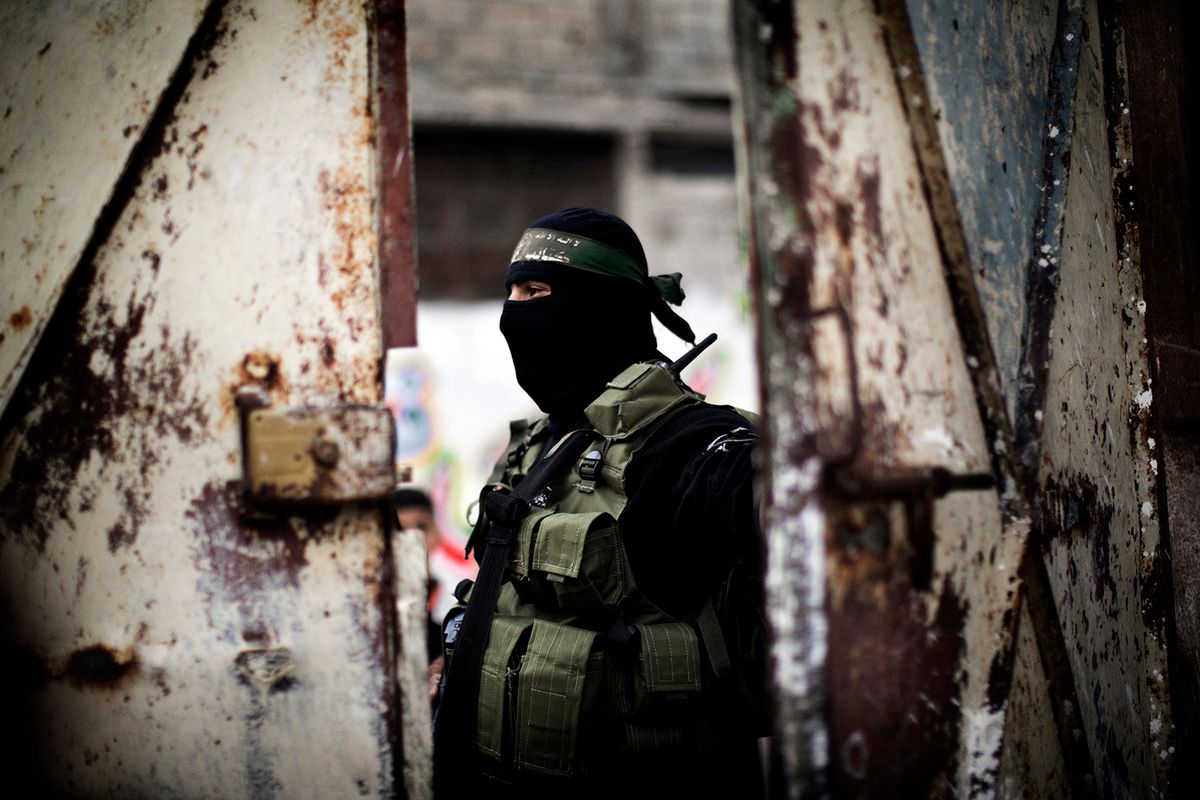 A gunman from  the Ezzedine al-Qassam Brigades, the armed wing of Hamas, guards the door of the house of their late leader Ahmed Jaabari, as mourners visit to pay their condolences to his family in Gaza City on November 22, 2012. Israeli politicians returned to the campaign trail as the streets of Gaza came back to life after a truce ended eight days of bloodshed, with both sides claiming victory while remaining wary. AFP PHOTO/MARCO LONGARI (Photo by MARCO LONGARI / AFP)
Hamász