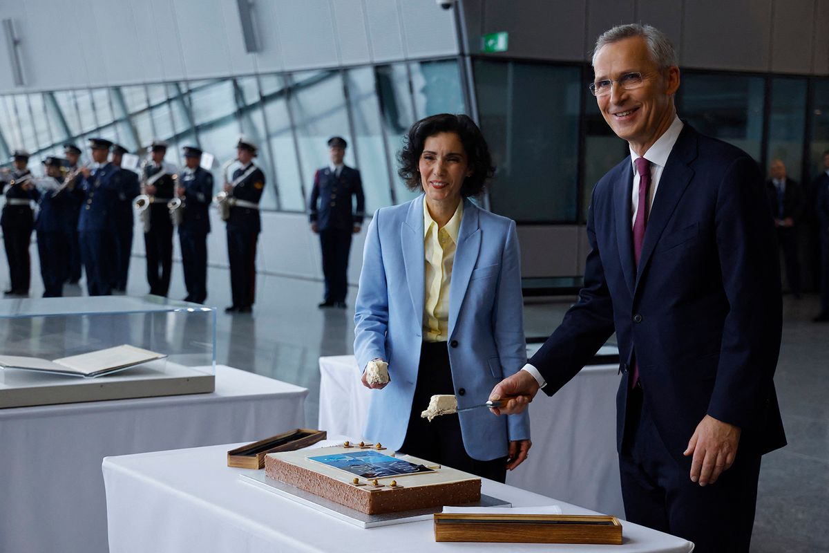 Belgian Minister for Foreign Affairs Hadja Lahbib (L) and North Atlantic Treaty Organization (NATO) Secretary General Jens Stoltenberg, each hold a slice of cake as they and foreign ministers celebrate the North Atlantic Treaty Organization (NATO) alliance's 75th anniversary at the NATO Headquarters in Brussels on April 4, 2024. The NATO military alliance on April 4, 2024, marks the 75th anniversary of the signing of its founding treaty in Washington. (Photo by Kenzo TRIBOUILLARD / AFP)