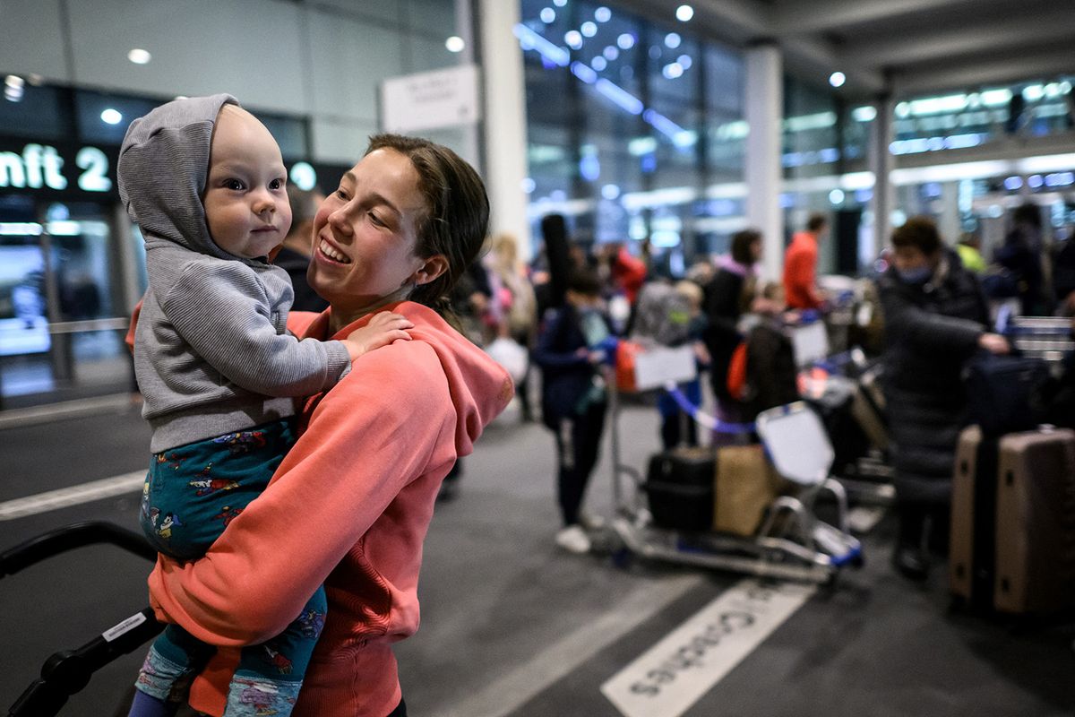 Ukrainian refugee Alona Chevchenko holds her baby at Zurich Airport after landing form Krakow in a plane chartered by a Swiss millionaire on March 22, 2022. Around 90 Ukrainians -- nearly all of them women and children -- are being flown to Switzerland to escape the violence in their conflict-torn country. The plane has been chartered by Swiss millionaire Guido Fluri, who says the loneliness and insecurity of his own troubled childhood has instilled in him a visceral sense of obligation to help those uprooted and in crisis. (Photo by Fabrice COFFRINI / AFP)