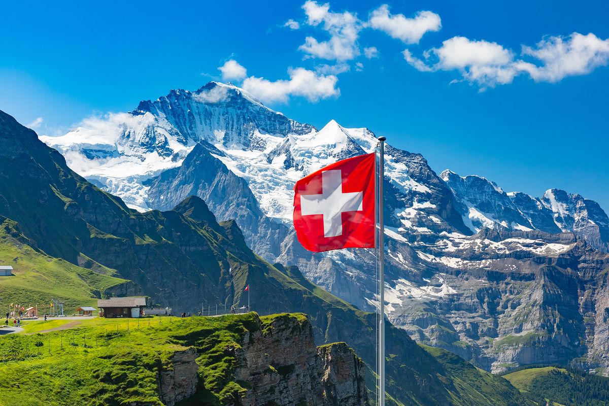 Swiss,Flag,Waving,And,Tourists,Admire,The,Peaks,Of,Monch