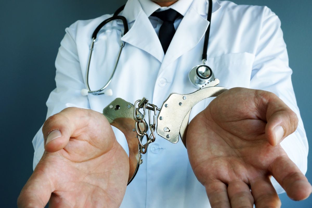 Medical malpractice concept. Doctor with handcuffs on hands., hálapénz