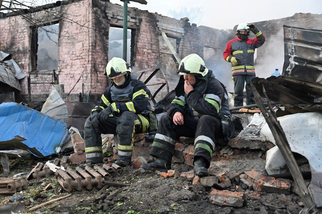 Firefighters rest after extinguishing a fire in a private house destroyed by a Russian drone attack in the suburbs of Kharkiv, on May 21, 2024, amid the Russian invasion in Ukraine. (Photo by SERGEY BOBOK / AFP)