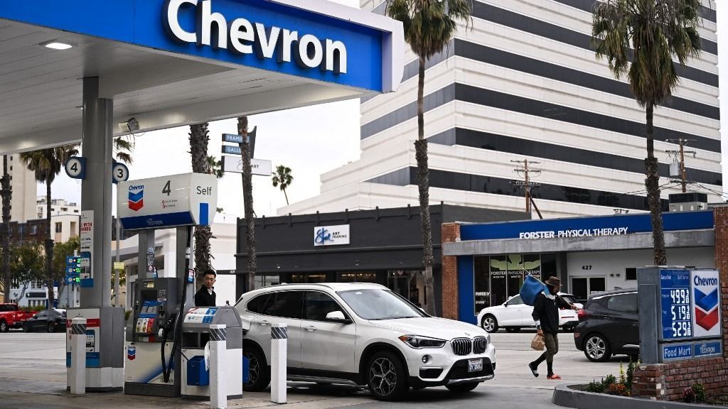 A customer pumps gasoline into a BMW vehicle at a Chevron gas station in Santa Monica, California on March 20, 2023. (Photo by Patrick T. Fallon / AFP)