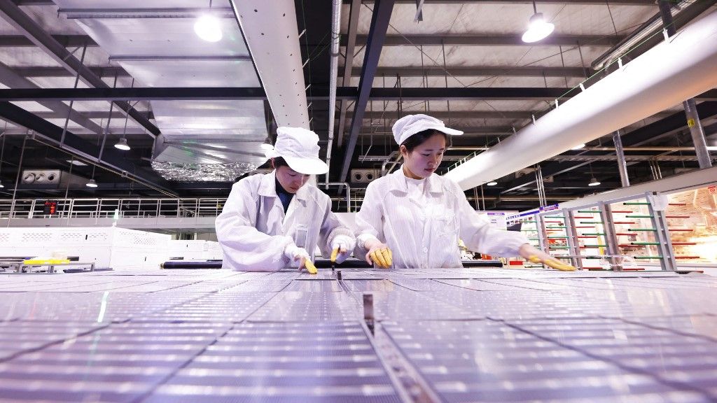 A worker is producing photovoltaic panel components for export orders at a new energy production workshop in Suqian, Jiangsu Province, China, on December 14, 2023. (Photo by Costfoto/NurPhoto) (Photo by CFOTO / NurPhoto / NurPhoto via AFP)