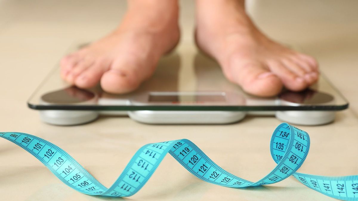 Tape,In,Front,Of,Woman,Standing,On,Floor,Scales,Indoors.