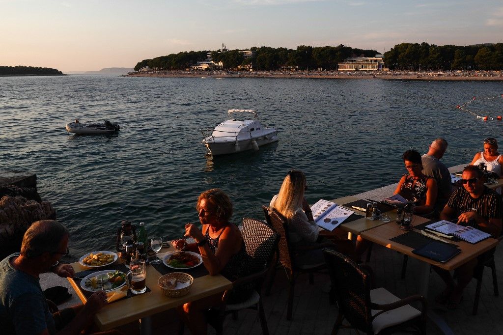 People sit in the restaurant nearby the Adriatic Sea, in Primosten, Croatia on September 13, 2021.  (Photo by Jakub Porzycki/NurPhoto) (Photo by Jakub Porzycki / NurPhoto / NurPhoto via AFP)