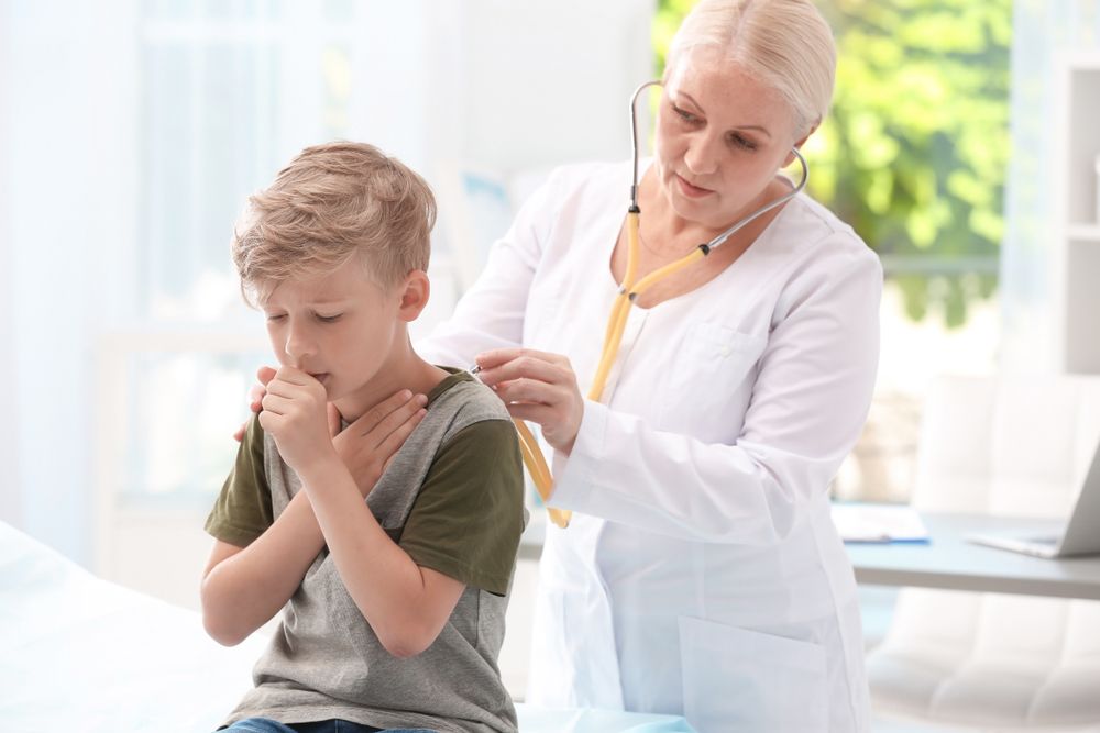 Doctor,Examining,Coughing,Little,Boy,At,Clinic