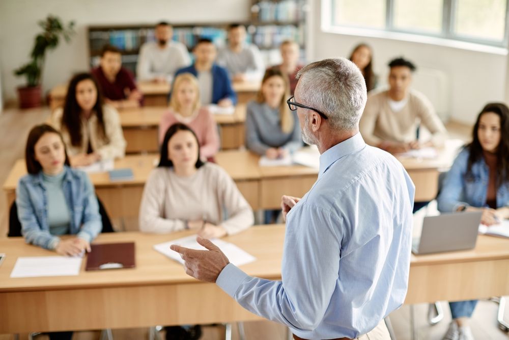 Back,View,Of,Mature,Professor,Giving,Lecture,To,Large,Group