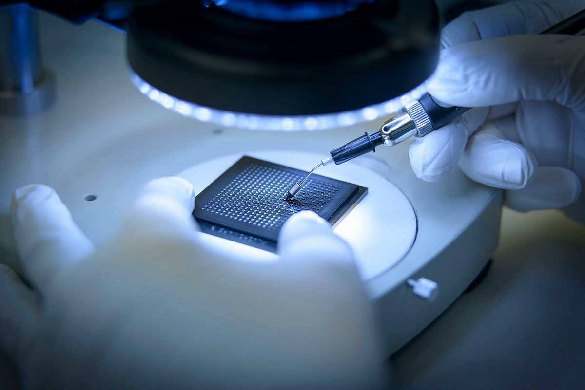 Electronics worker checking small electronic chips in clean room laboratory, close up, csip