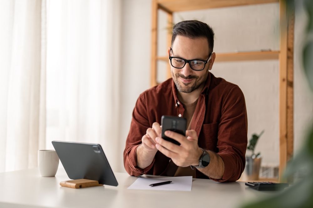 Happy,Smiling,Businessman,Wearing,Casual,Clothes,And,Using,Modern,Smartphone, sms-értesítés