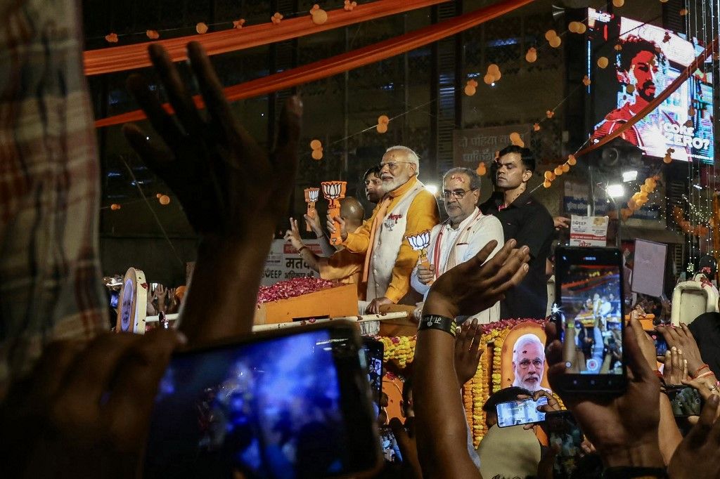 India miniszterelnöke és a kormányzó Bharatiya Janata Párt vezetője, Narendra Modi köszönti támogatóit, miközben részt vesz egy roadshow-n a választási jelölési papírjainak benyújtásának előestéjén Varanasiban