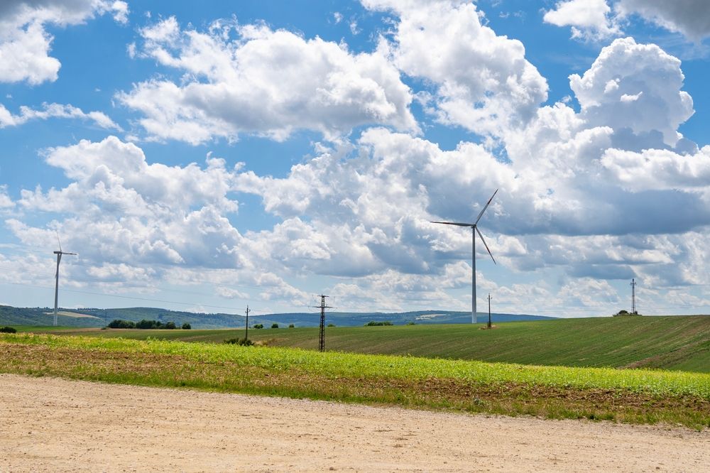 Wind,Turbine,In,Summer,Landscape,In,Front,Of,Cloudy,Sky