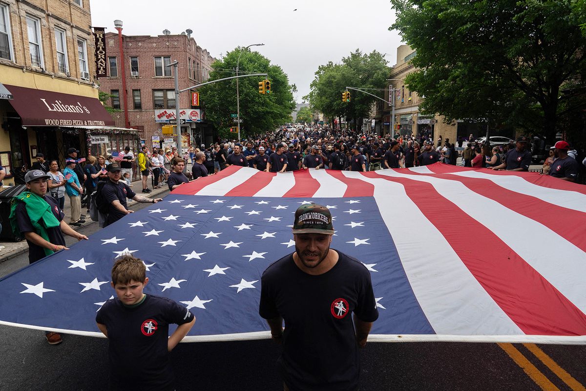 Participants carry a large American flag during the 157th Brooklyn Memorial Day Parade in New York City on May 27, 2024. (Photo by Adam GRAY / AFP)