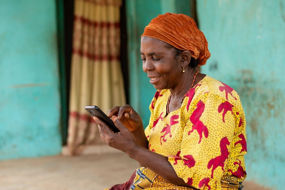 Happy,Elderly,African,Woman,Using,Her,Mobile,Phone